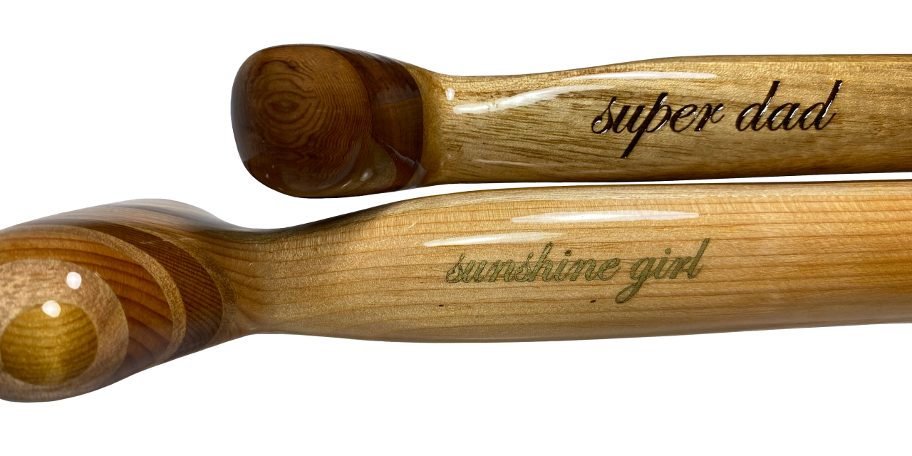 Two wooden sup paddles with personalised message laser-engraved on the shaft